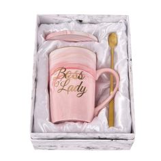 a pink coffee mug and spoon in a box with the words boss's day written on it