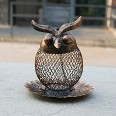 an owl statue sitting on top of a metal stand