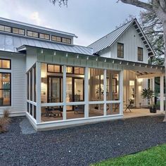 a white house with lots of windows on the front and side of it's roof