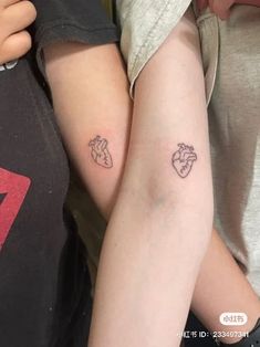 two people with small tattoos on their arms