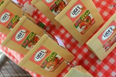 several bags of apples are hanging on a table with red and white checkered cloth