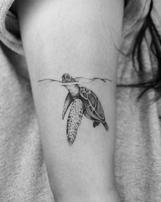 a small turtle tattoo on the arm