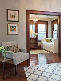 a living room filled with furniture and pictures hanging on the wall above a door way