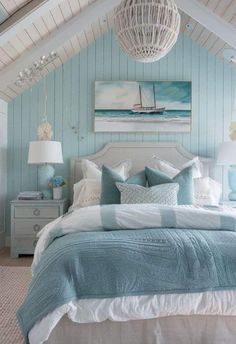 a bedroom with blue walls and white bedding, an ocean themed painting on the wall