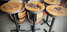 four wooden barrels sitting next to each other on top of metal stools in a room