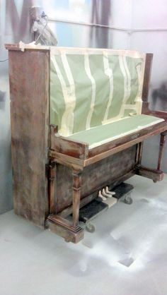 an old wooden bench with a sheet over it's seat and wheels on the floor