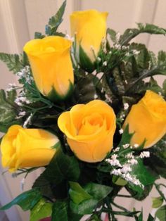 a vase filled with yellow roses on top of a table