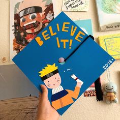 a hand holding up a blue book with the words believe it written on it in front of various pictures