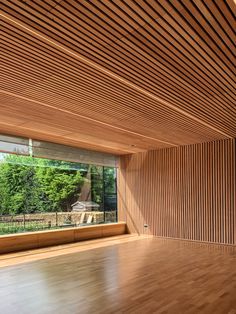 an empty room with wood flooring and large windows