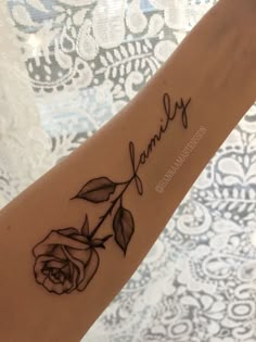 a woman's arm with a tattoo that says family and a rose on it