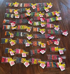 a wooden table topped with lots of colorful candy wrappers covered in happy birthday messages