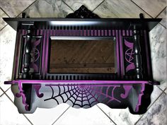 a purple and black vanity with spider web on it