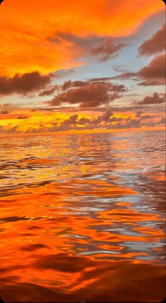 an orange and yellow sunset over the ocean