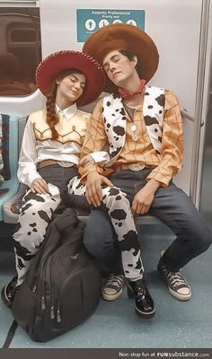 two people dressed in costumes sitting on a subway train together, one wearing a cowboy hat and the other with a cow print shirt