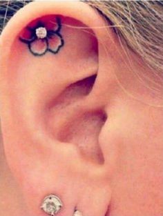 a close up of a person's ear with a flower on it