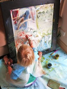 a young child is playing with an art project