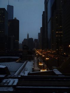 a city street filled with lots of traffic next to tall buildings in the night time