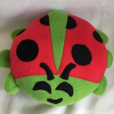 a ladybug stuffed animal laying on top of a white sheet