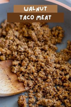 a wooden spoon full of taco meat on top of a blue plate with the words walnut taco meat