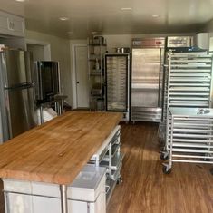 a large kitchen with stainless steel appliances and wooden counter tops in front of the refrigerators