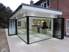 a house with glass walls and an open kitchen