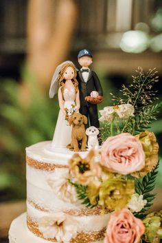 a wedding cake decorated with flowers and figurines