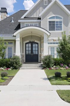 the front entrance to a house with landscaping around it