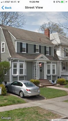 a car parked in front of a house on the google street view page with an image of two story houses behind it