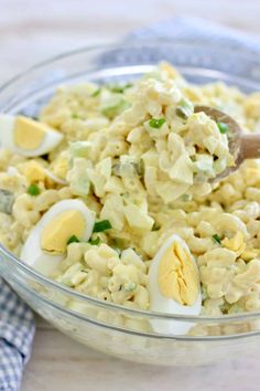 a bowl filled with macaroni salad and an open hard boiled egg on top