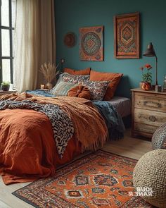 a bedroom with blue walls and orange bedspread, rugs and artwork on the wall