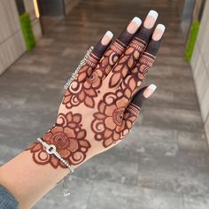 a woman's hand is decorated with henna and bracelets on her wrist