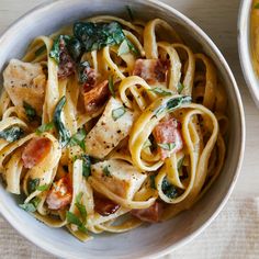 two bowls filled with pasta and meat on top of a table