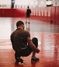 a man sitting on the ground in a gym