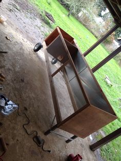 a wooden cabinet sitting in the middle of a yard