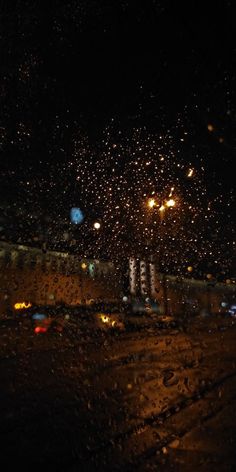 rain is falling down on the street at night