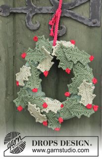 a crocheted christmas wreath hanging on a door