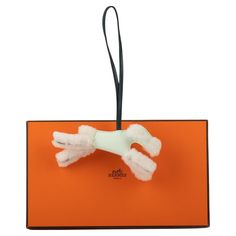 an orange luggage tag with a white dog paw on it's front and back end