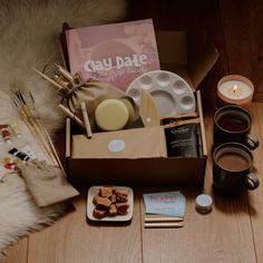 an open box with coffee, cookies and other items on the floor next to it