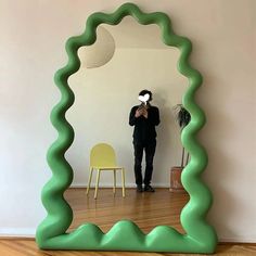 a person standing in front of a mirror with their reflection on the wall behind it