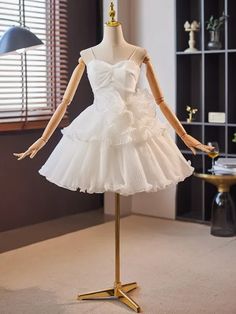 a mannequin wearing a white dress in front of a window