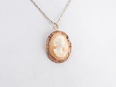 This lovely pendant is crafted in wonderful tones of peach and pink with accents of creamy white! Polished 14 karat rose gold comprises the frame, while the cameo at the center is carved from a traditional conch shell. This pendant does not come with the chain shown. Please feel free to contact us, we will help you find the perfect chain for your style and budget! Metal: 14K Rose Gold Gem: Shell Cameo Gem Measurements: 19.7 x 14.5 mm, Oval Measures: 21 x 33 mm, with bail Marks: "14K" Stamped on the reverse Elegant Cameo Round Pendant Jewelry, Rose Gold Cameo Jewelry Gift, Rose Gold Cameo Jewelry For Gifts, Heirloom Cameo Pendant Jewelry, Yellow Gold Cameo Round Pendant Necklace, Yellow Gold Cameo Necklace With Round Pendant, Yellow Gold Cameo Pendant Necklace, Heirloom Cameo Pendant Necklace, Elegant Oval Carved Necklaces