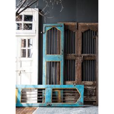 two wooden doors with bars on them in front of a black wall and white door