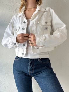 - Vintage Calvin Klein white cropped denim jacket - 100% cotton - Made in Canada - Tagged S Chest: 20" Length: 18.5" Sleeve: 23.5" We are not responsible for lost, stolen, or damaged packages once they have been shipped. Any additional customs duties or taxes incurred on international orders are the responsibility of the buyer. Please note that our items are vintage and may have minor flaws or imperfections due to their age, which adds to their unique character. Trendy Cropped Denim Workwear Jacket, Relaxed Fit Cropped Jacket For Streetwear, Trendy Cropped Denim Jacket For Work, Cropped Cotton Denim Jacket For Summer, Summer Cropped Cotton Denim Jacket, Streetwear Cropped Jacket With Pockets, Cropped Streetwear Jacket With Pockets, Spring Cropped Cotton Denim Jacket, Spring Cotton Cropped Denim Jacket