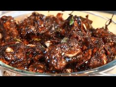 a glass bowl filled with meat covered in sauce