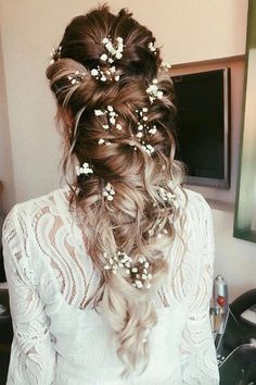 the back of a woman's head, with flowers in her hair and braid