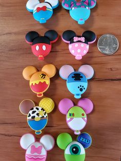 several mickey mouse magnets on a wooden table