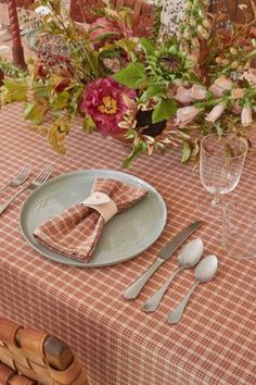 the table is set with utensils, plates and napkins for dinner guests