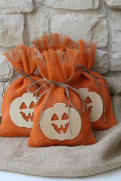 two bags with pumpkin faces on them sitting next to a brick wall