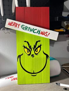 a green box with a grin face painted on it's front and the words merry grinmas above it