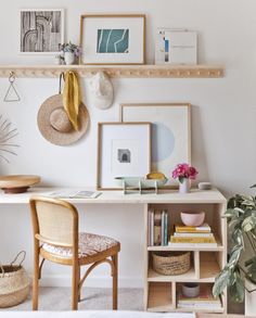 a white desk topped with lots of shelves filled with pictures and other items next to a potted plant